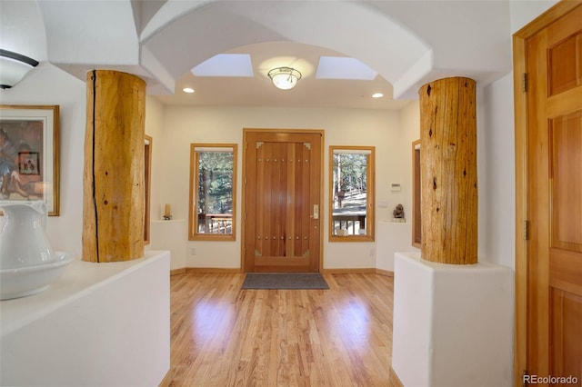 foyer with decorative columns and light hardwood / wood-style flooring