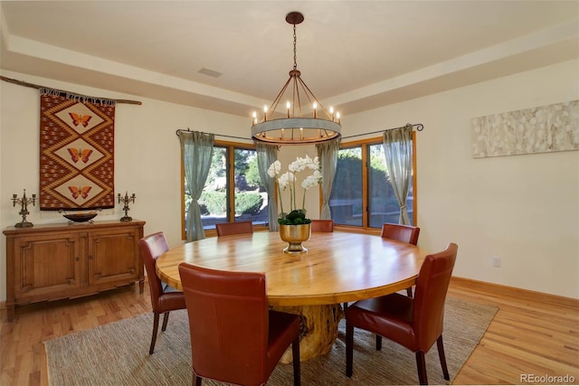 dining room featuring a notable chandelier, a healthy amount of sunlight, and light hardwood / wood-style flooring