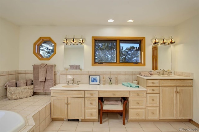 bathroom featuring vanity, tile patterned floors, and a tub to relax in