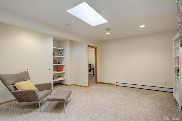 sitting room featuring built in shelves, a baseboard heating unit, and light carpet