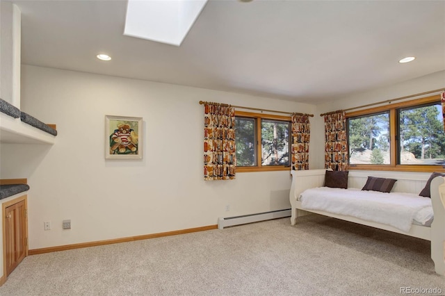 carpeted bedroom with a baseboard heating unit and a skylight