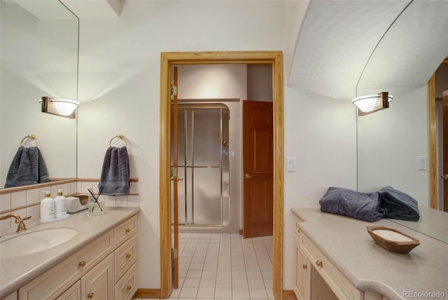 bathroom with backsplash, a shower with shower door, tile patterned floors, and vanity