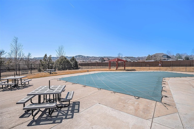 pool featuring a patio area, fence, and a mountain view