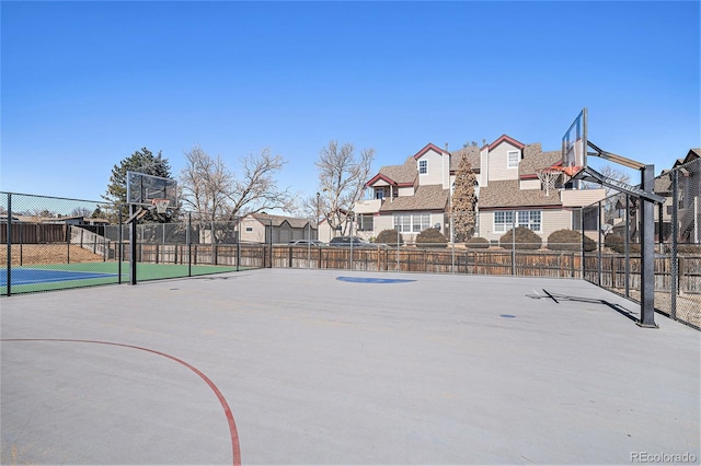 view of sport court featuring a residential view, community basketball court, and fence