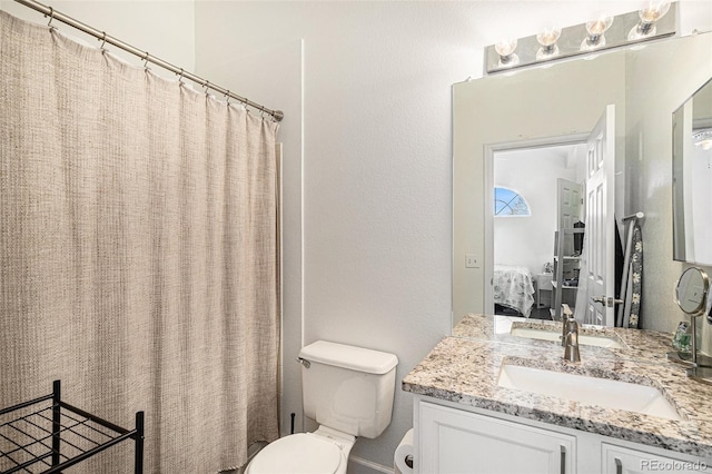 ensuite bathroom featuring toilet, a shower with shower curtain, connected bathroom, and vanity