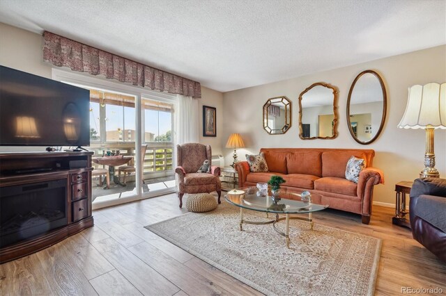 living room with a textured ceiling and light wood-type flooring