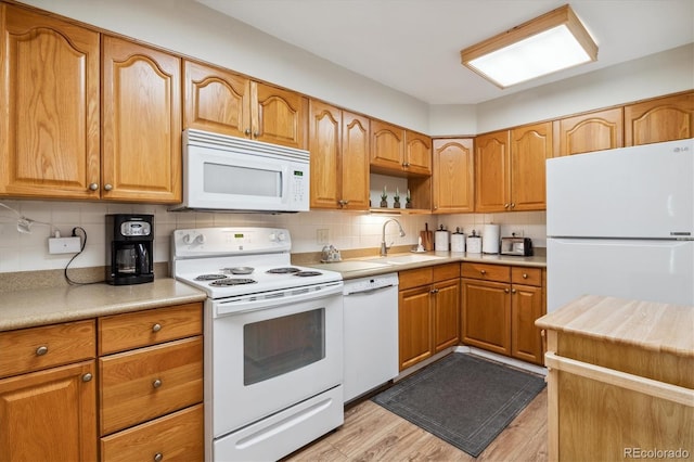 kitchen featuring backsplash, light hardwood / wood-style flooring, white appliances, and sink