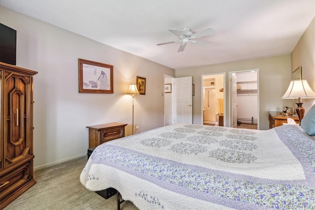 bedroom featuring carpet flooring, ensuite bath, ceiling fan, a walk in closet, and a closet