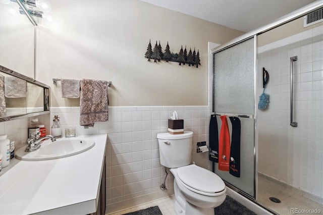 bathroom featuring vanity, tile patterned floors, toilet, tile walls, and walk in shower