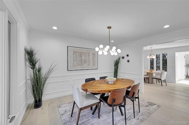 dining room featuring a notable chandelier, crown molding, and light hardwood / wood-style floors