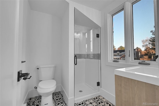 bathroom with vanity, toilet, tile patterned floors, and a shower with door