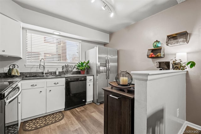 kitchen featuring sink, white cabinetry, light wood-type flooring, track lighting, and appliances with stainless steel finishes