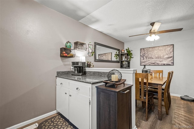 kitchen featuring ceiling fan, dark hardwood / wood-style flooring, a textured ceiling, and white cabinets