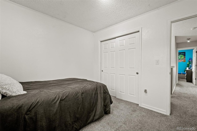 bedroom featuring light colored carpet, a closet, and a textured ceiling