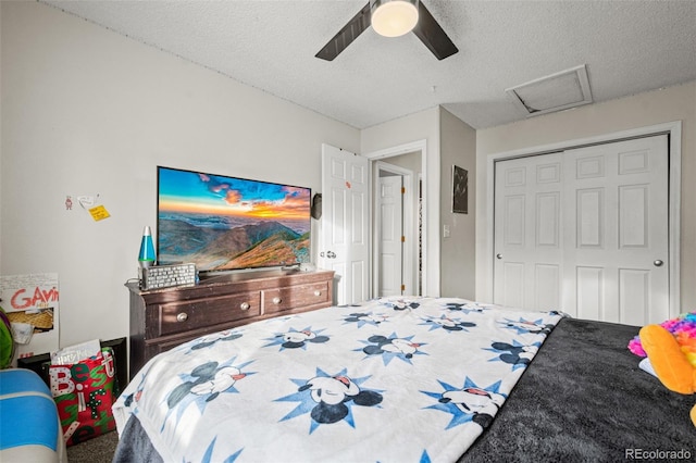 bedroom with ceiling fan, carpet floors, a closet, and a textured ceiling