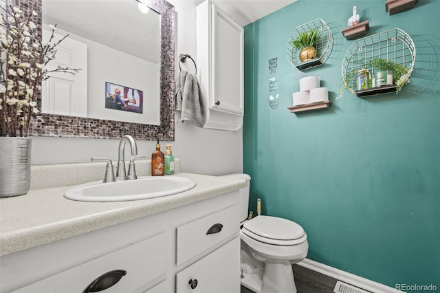 bathroom with hardwood / wood-style flooring, vanity, and toilet