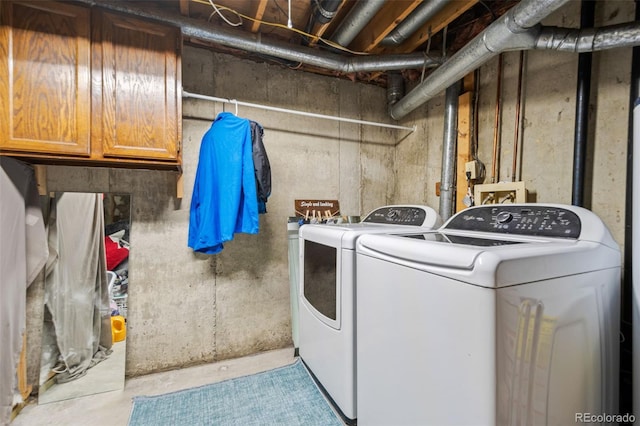 washroom featuring cabinets and washer and clothes dryer