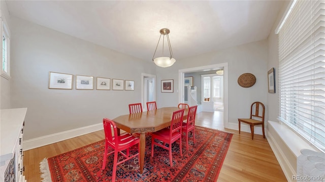 dining area with light wood-type flooring and baseboards