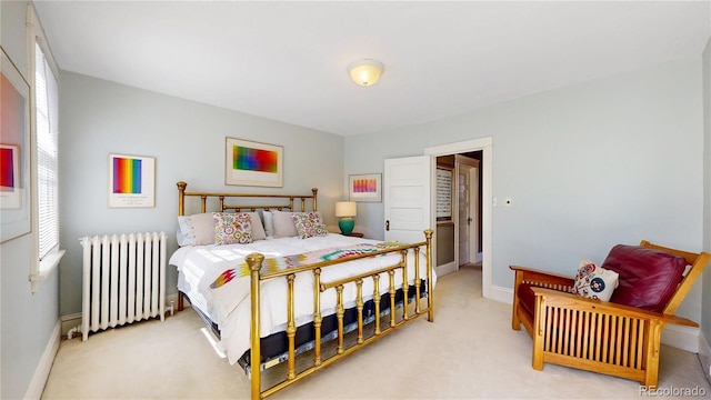 bedroom with baseboards, light colored carpet, and radiator heating unit