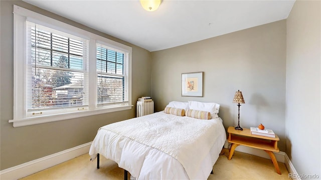 carpeted bedroom with baseboards and radiator