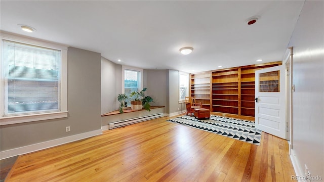 workout room with built in features, recessed lighting, hardwood / wood-style floors, baseboard heating, and baseboards