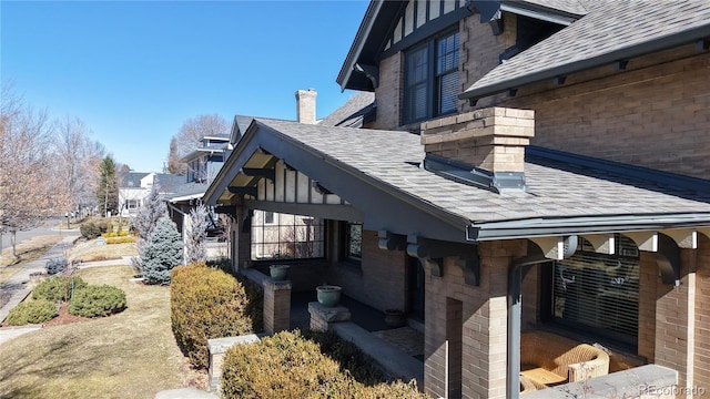 view of side of home featuring roof with shingles and a chimney