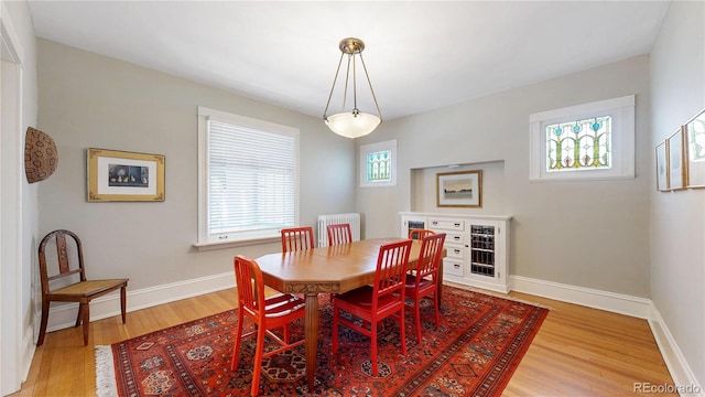 dining room featuring light wood finished floors and baseboards