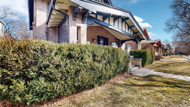 view of side of property with a yard and brick siding