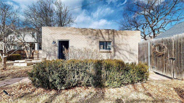 exterior space with a vegetable garden, brick siding, and fence