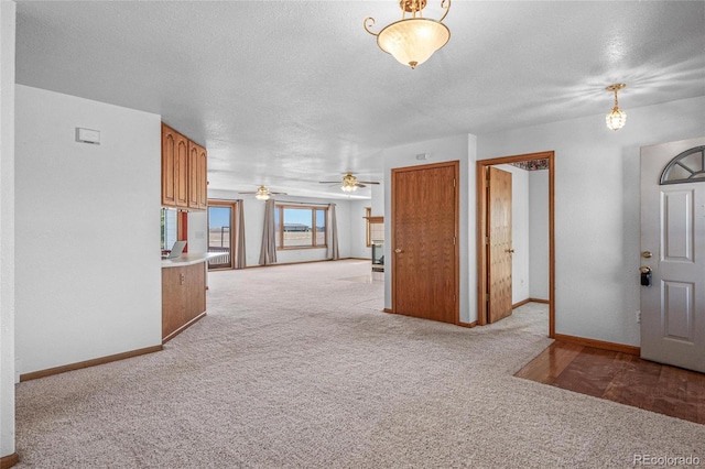 interior space with light carpet, a textured ceiling, and ceiling fan