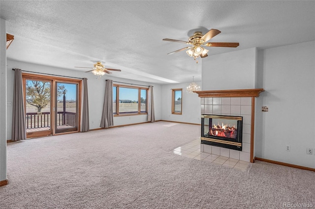 unfurnished living room with light carpet, a fireplace, a textured ceiling, and ceiling fan with notable chandelier