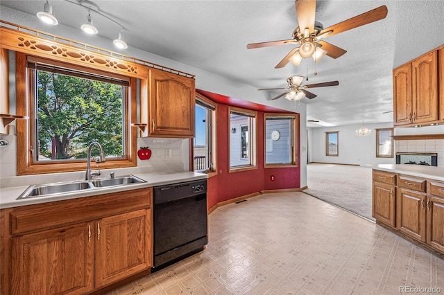 kitchen with black dishwasher, sink, a textured ceiling, and backsplash