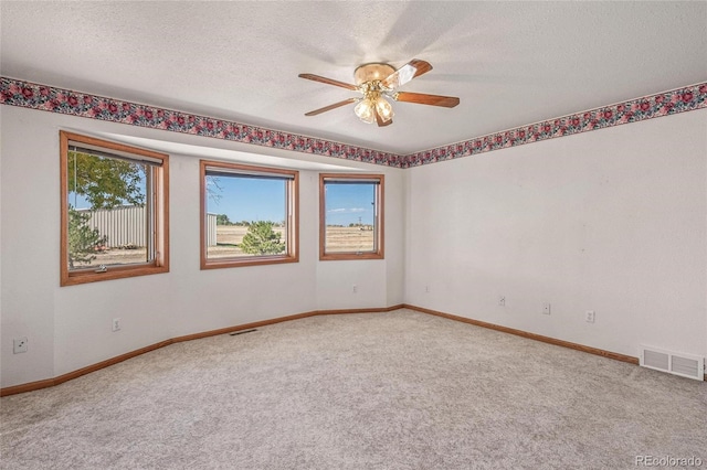 carpeted empty room with a textured ceiling and ceiling fan