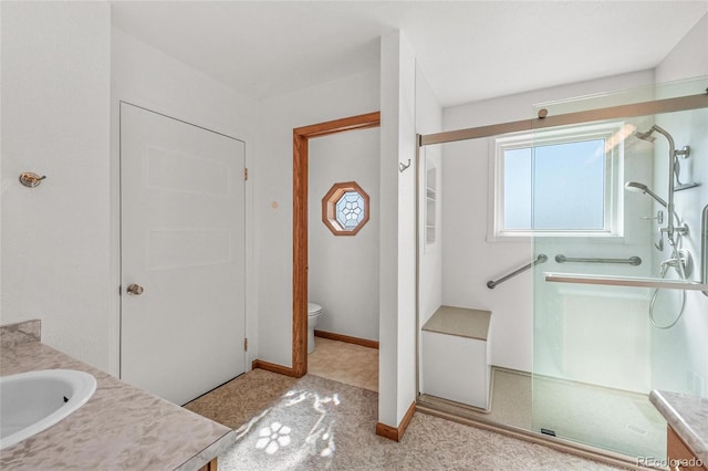 bathroom featuring toilet, vanity, and a shower with door