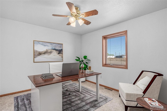 office space with a textured ceiling, carpet, and ceiling fan