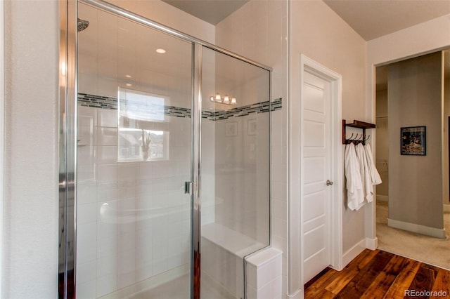 bathroom with an enclosed shower and hardwood / wood-style flooring