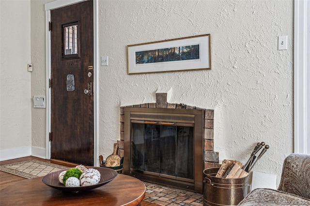 living area featuring a glass covered fireplace and a textured wall