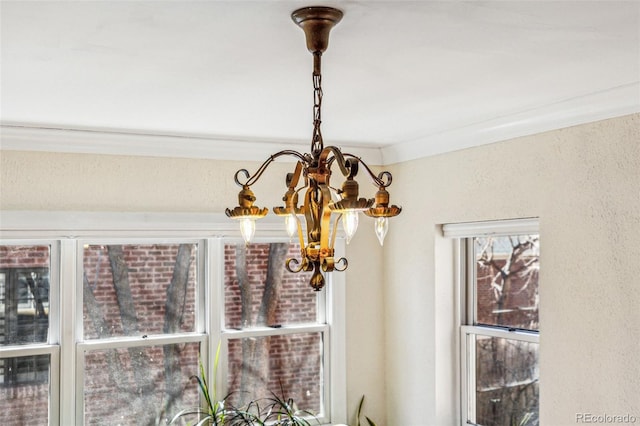 details featuring ornamental molding and a notable chandelier