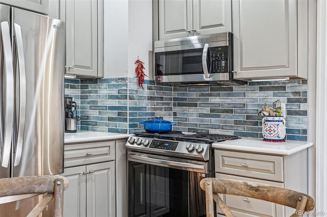 kitchen with light countertops, appliances with stainless steel finishes, and decorative backsplash