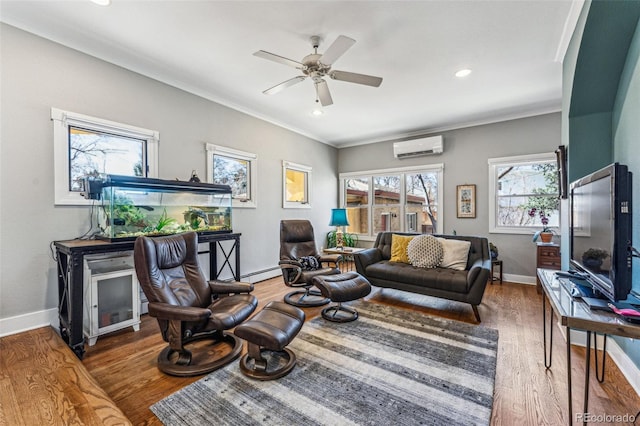 living area featuring an AC wall unit, ornamental molding, wood finished floors, and baseboards