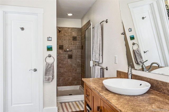 full bathroom with a shower stall and vanity