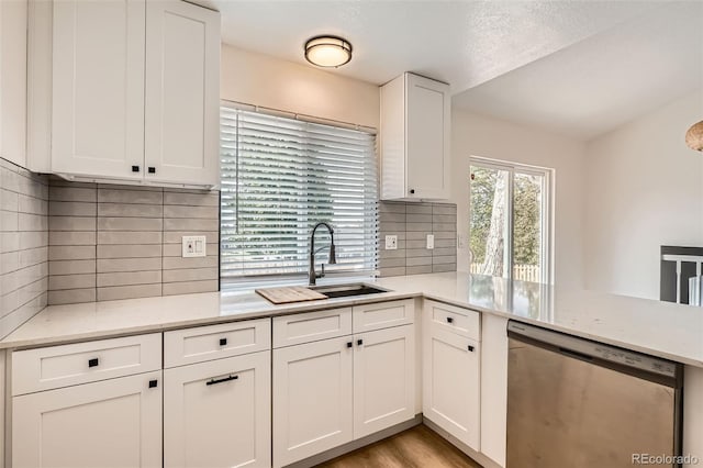 19859 E Prentice Pl, Centennial, CO 80015 - kitchen with stainless steel dishwasher, white cabinets, decorative backsplash, light stone countertops, and a peninsula