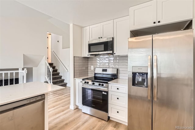 19859 E Prentice Pl, Centennial, CO 80015 - kitchen featuring stainless steel appliances, white cabinets, light wood finished floors, decorative backsplash, and light stone countertops
