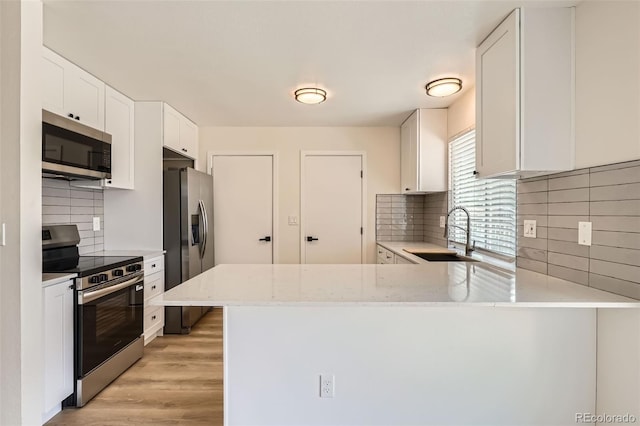 19859 E Prentice Pl, Centennial, CO 80015 - kitchen featuring appliances with stainless steel finishes, decorative backsplash, light stone counters, light wood-style flooring, and white cabinets