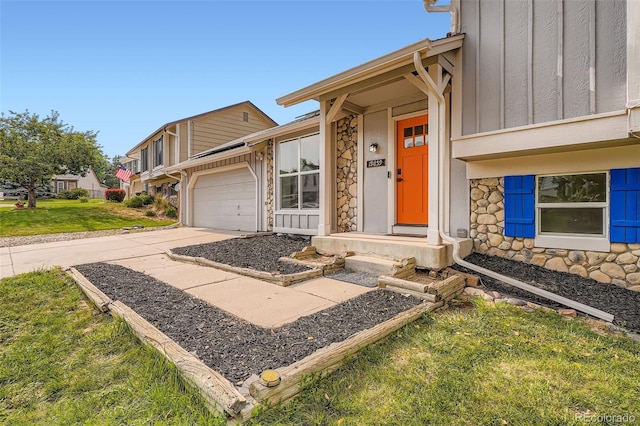 19859 E Prentice Pl, Centennial, CO 80015 - property entrance with stone siding, board and batten siding, driveway, a yard, and an attached garage