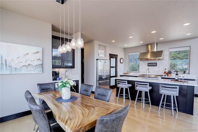 dining room with light wood finished floors, baseboards, and recessed lighting
