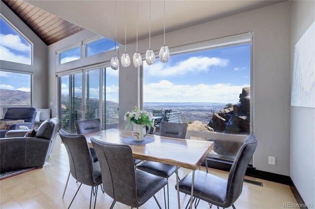 dining room featuring wood ceiling, baseboards, vaulted ceiling, and light wood-type flooring