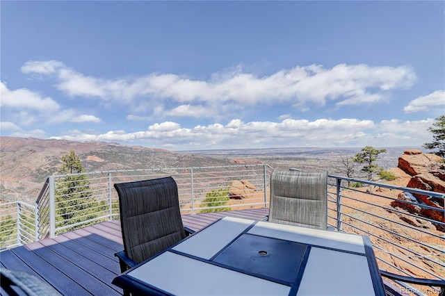 deck with a mountain view and outdoor dining space