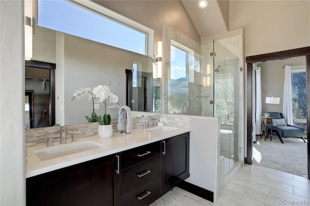full bathroom with a stall shower, a sink, and vaulted ceiling