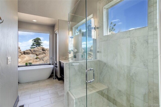 full bath featuring a shower stall and a freestanding bath